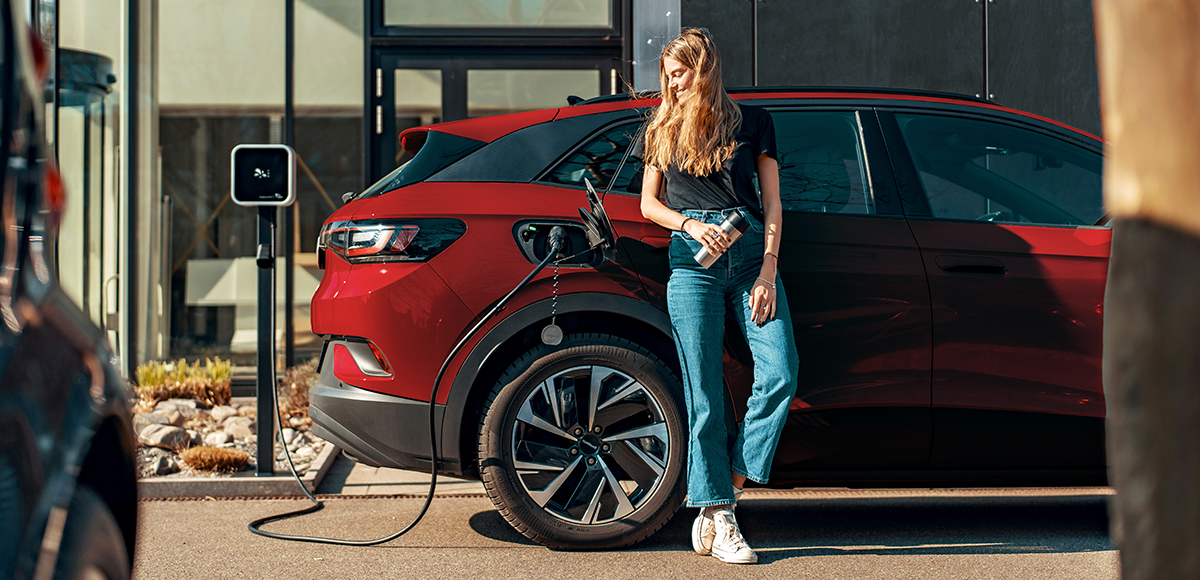 woman charging ev out of home | CB | 1200x580