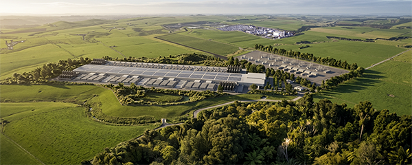 Aerial view of the potential data centre surrounded by green farmland, showing the main facility building and rows of cooling equipment