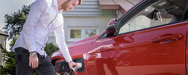 man charging EV at home